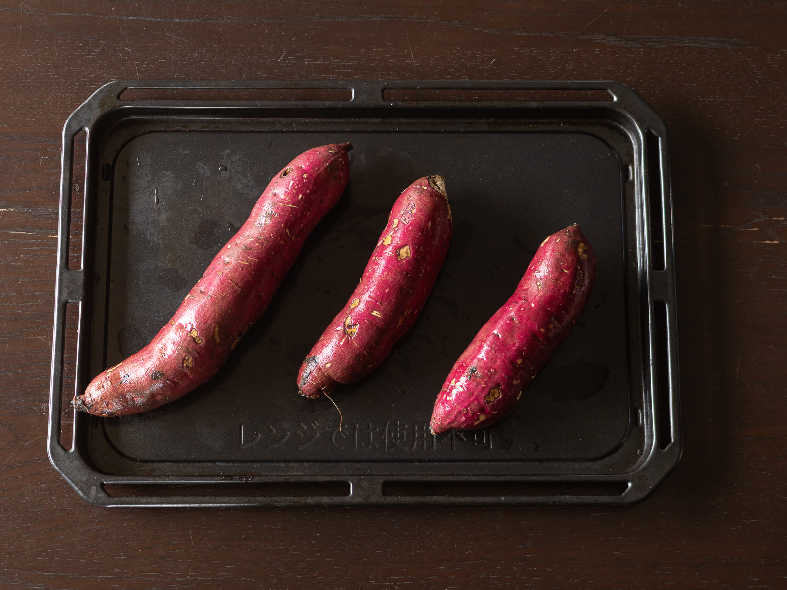 天板に並べた濡れたままのさつま芋、オーブンで焼く準備
