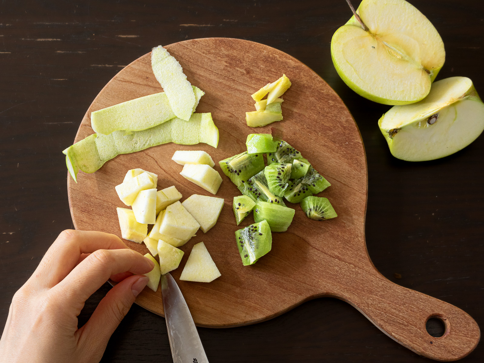 まな板の上でスライスしたりんごと硬いキウイ