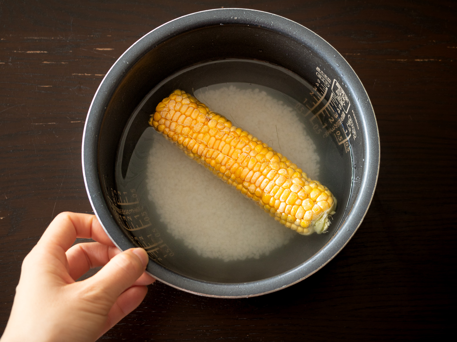 炊飯器にとうもろこしとお米を入れる様子