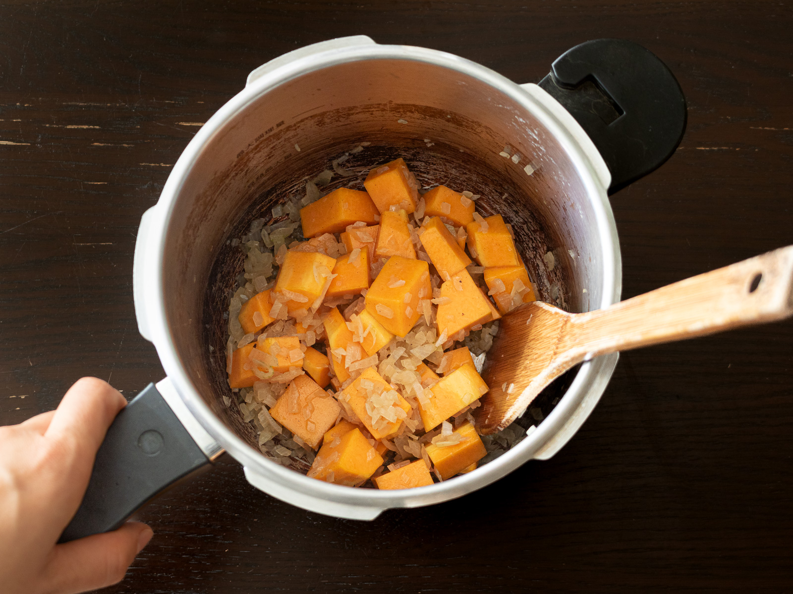 玉ねぎの入った圧力鍋に角切りのバターナッツかぼちゃを加える
