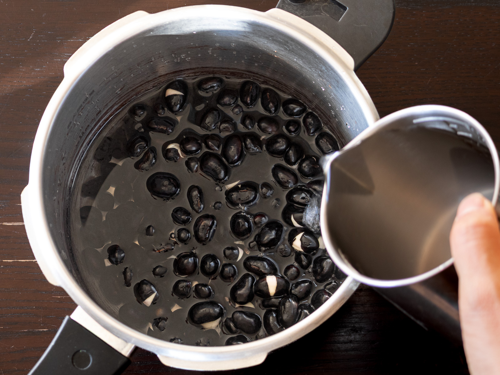 圧力鍋に黒豆と水を入れた状態。下茹で工程