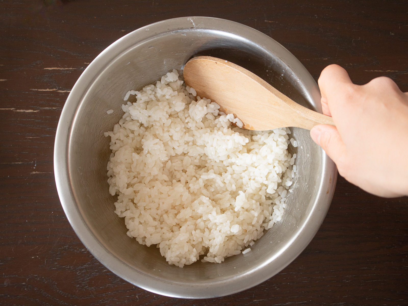 寿司酢を加えたごはんをしゃもじで切るように混ぜ、酢飯を作る工程