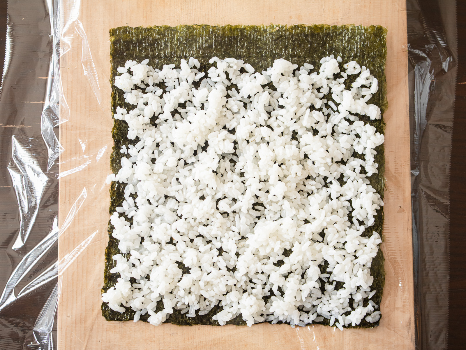 海苔の上に酢飯を薄く広げ、奥を少し空けている太巻きの下準備