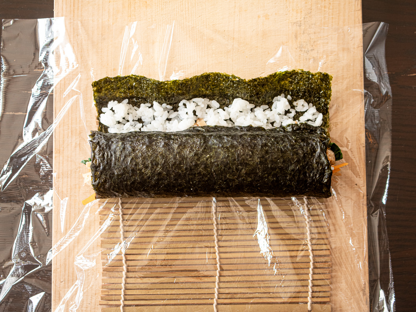 巻いた太巻きを手前に引くように軽く押さえ、形を整えた後。太巻き作りの工程