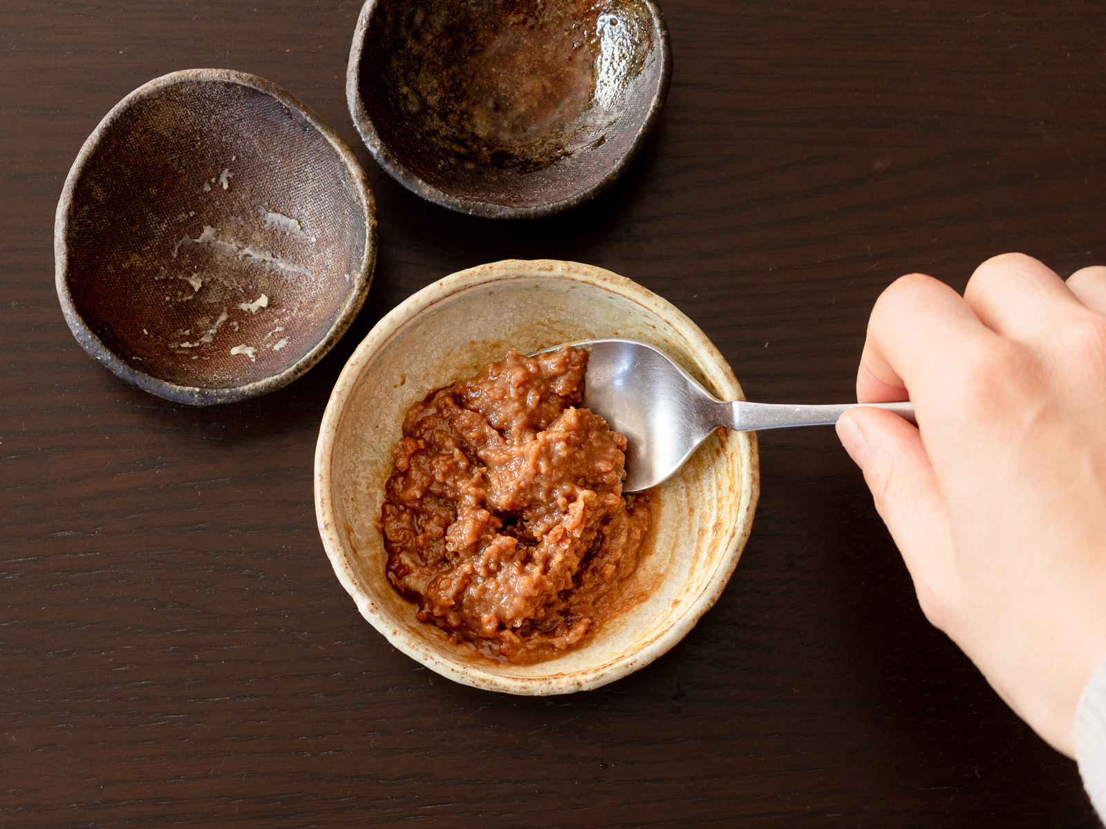 きのこのそぼろ炒めの調味料を全て容器に入れ混ぜ合わせている様子