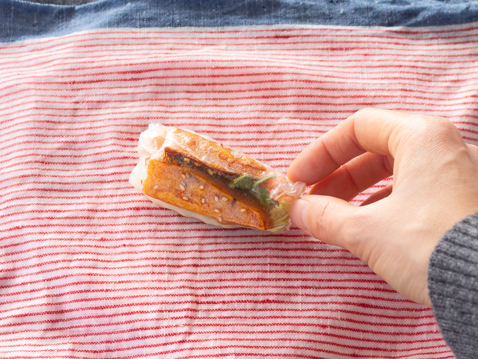 生春巻きを最後まで巻き上げて完成させる工程。野菜だけのヴィーガン生春巻きの仕上げ