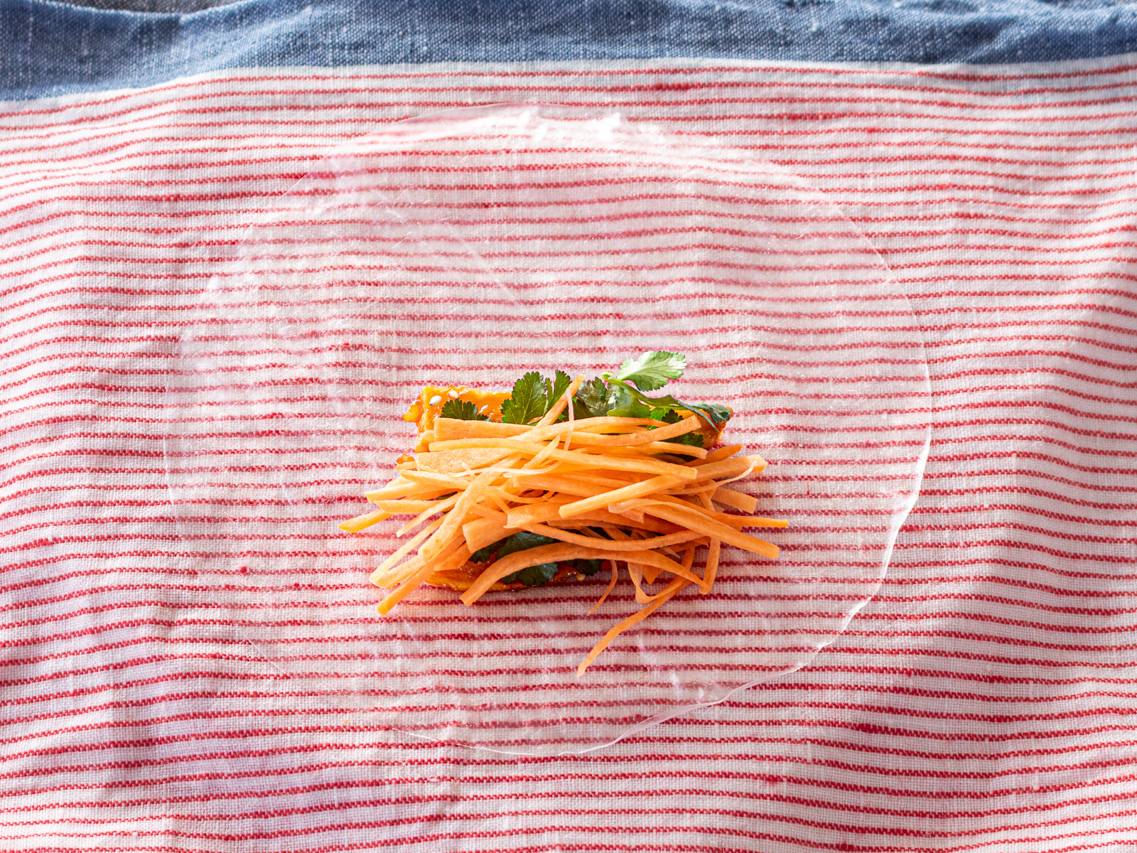 千切りにんじんを生春巻きの具材としてのせる工程。