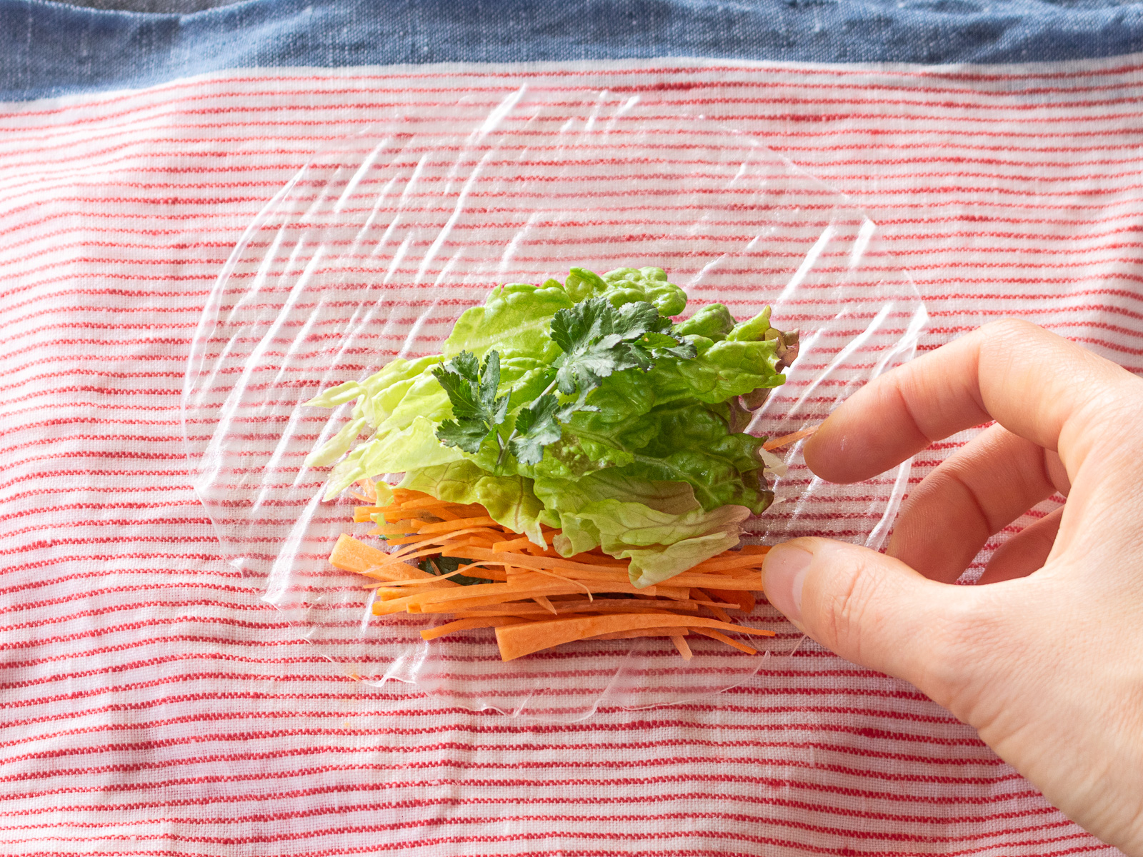 レタスを小さくちぎって生春巻きにのせる様子。