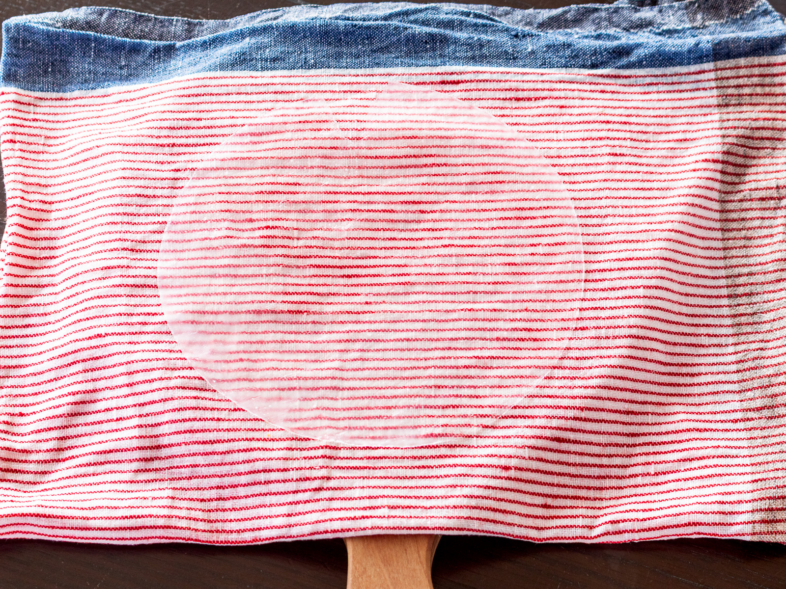 生春巻きの巻き方に使う道具。濡れた布、をまな板の上に敷いて。ライスペーパーを戻すための準備