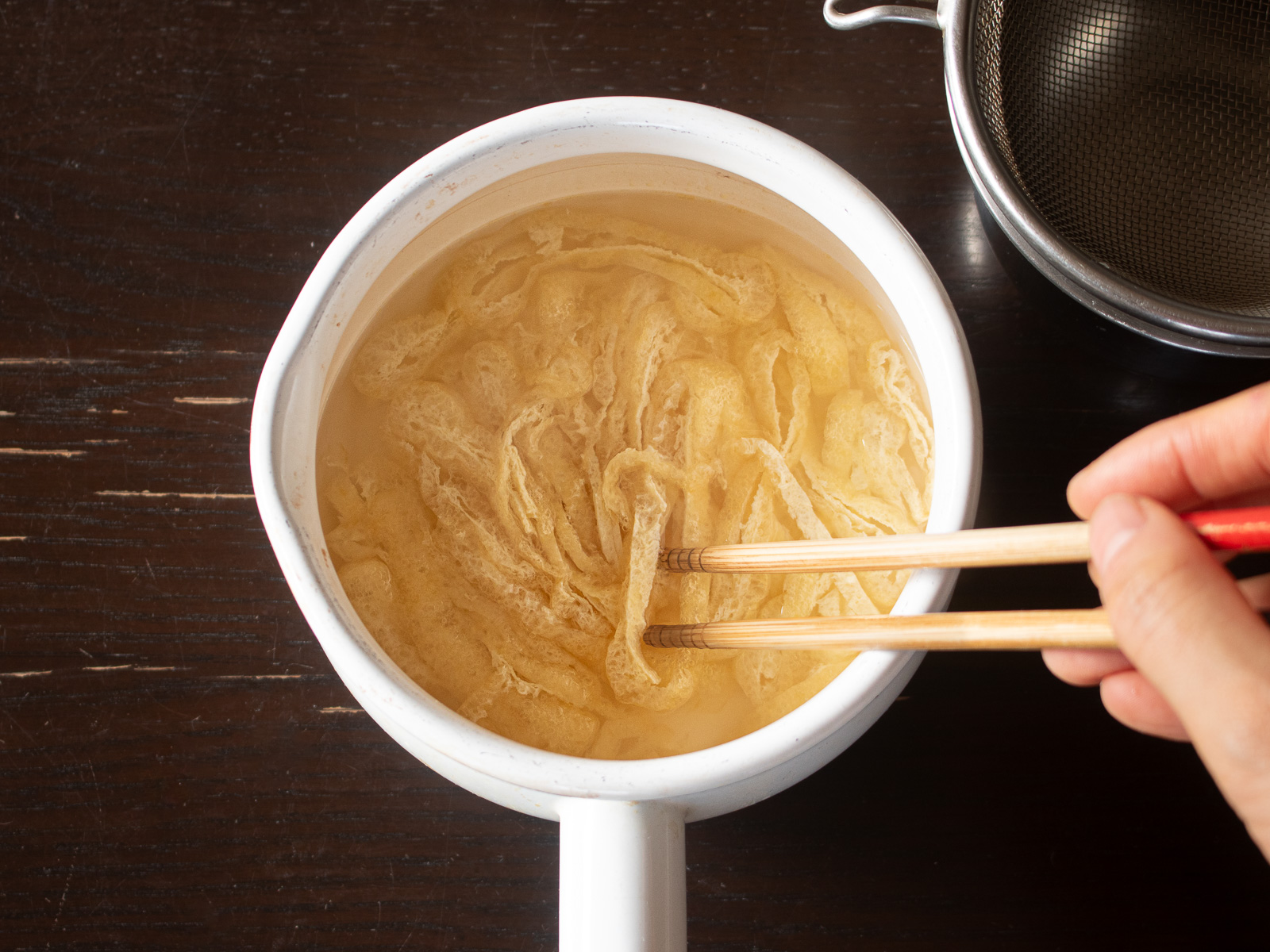 油揚げを下茹でして油抜きしている様子