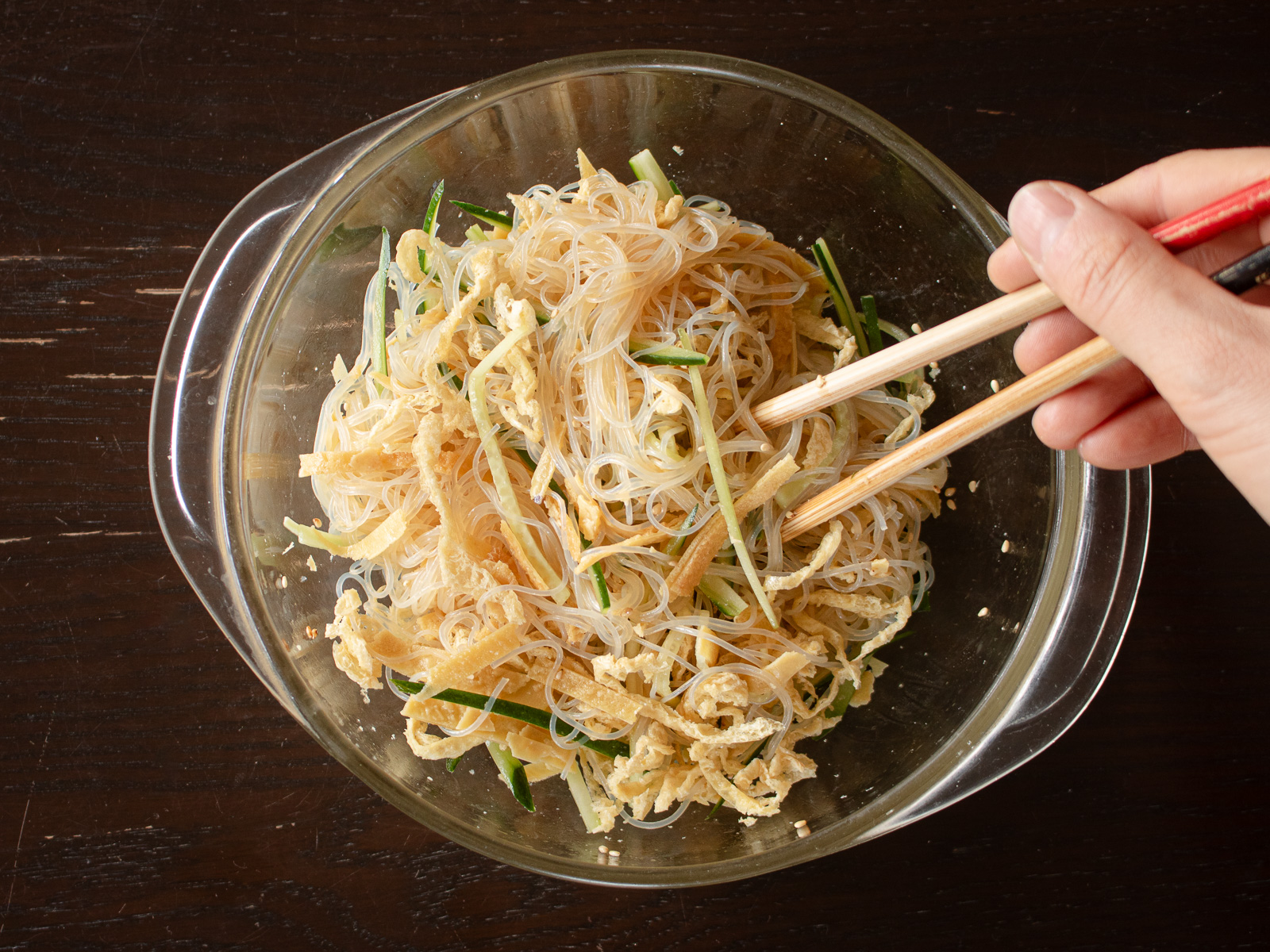 具材を加えて中華風春雨サラダを仕上げている様子