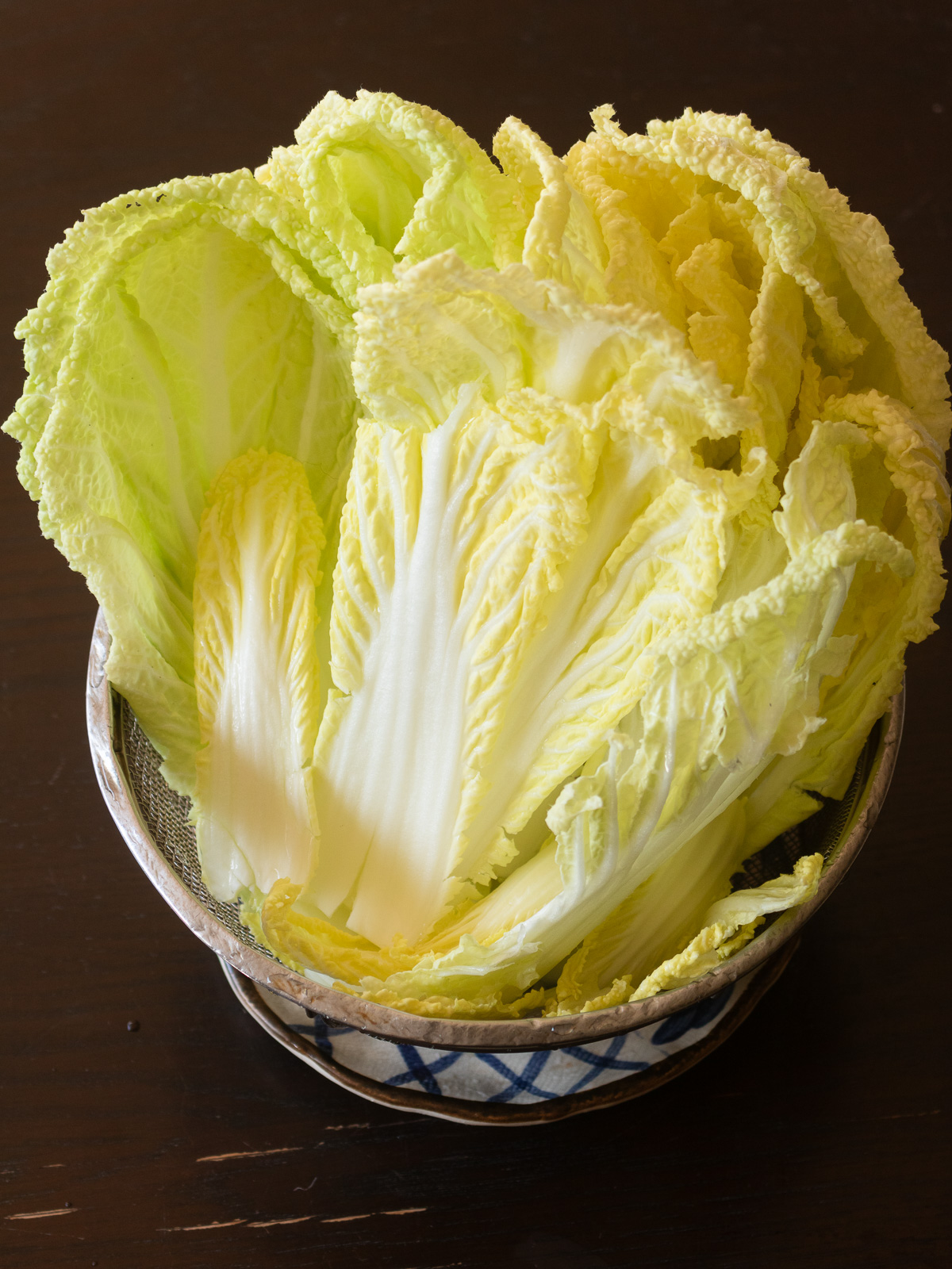 ヴィーガン白菜キムチ用に白菜を一枚ずつ洗いザルにあけて水を切っているところ