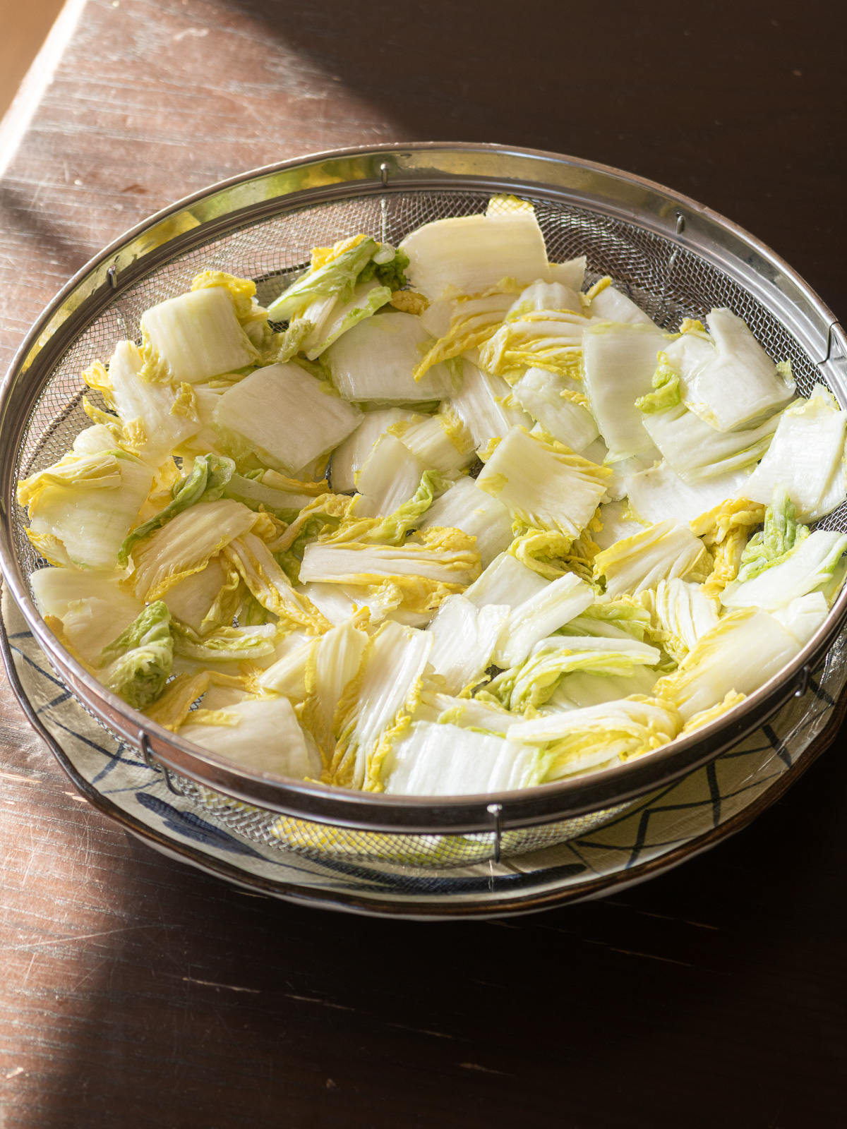 ザルに塩漬けした白菜をあけて水気を切っている様子