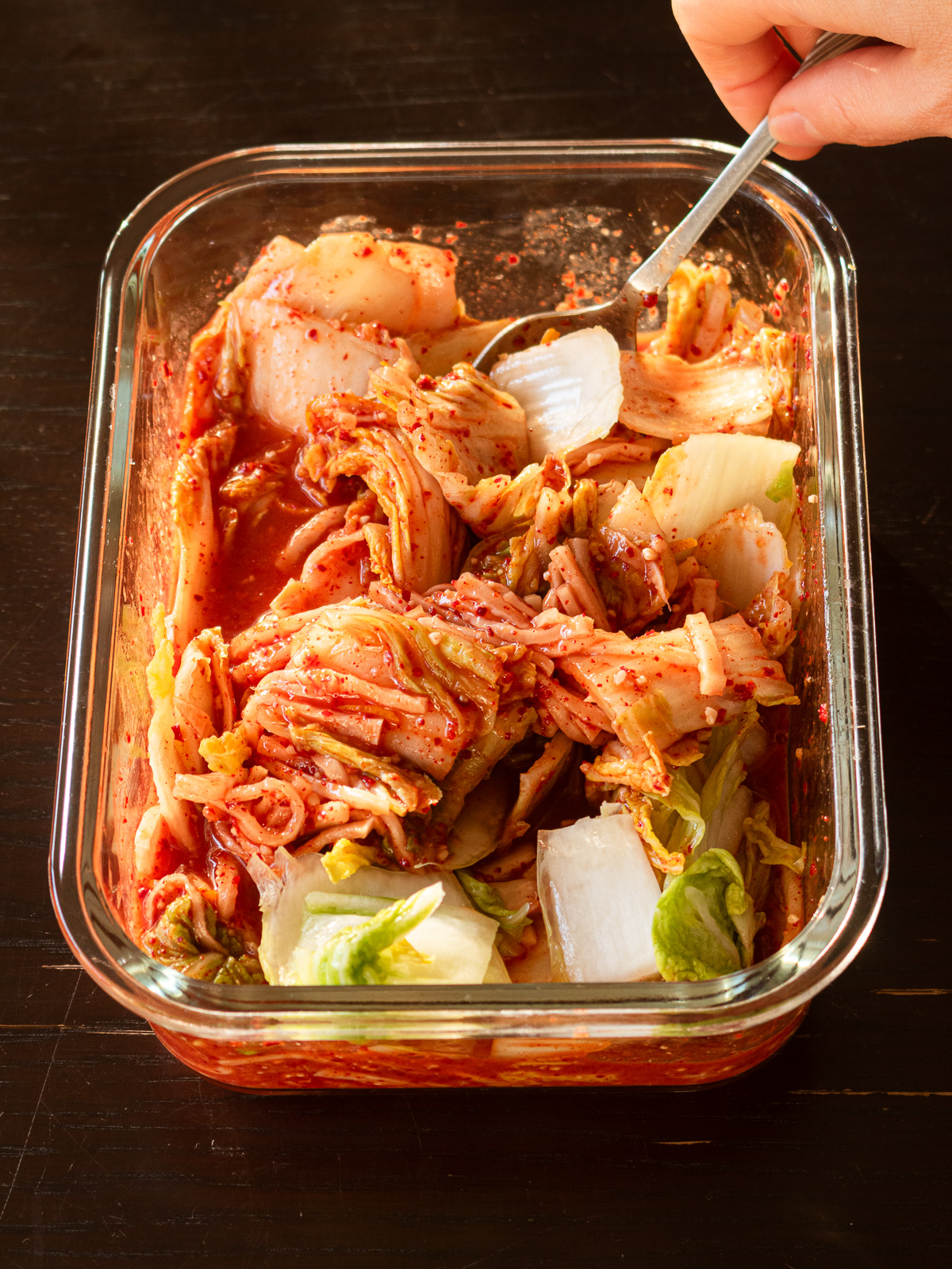 水切りした白菜の塩漬けをヤンニョムと絡めている様子