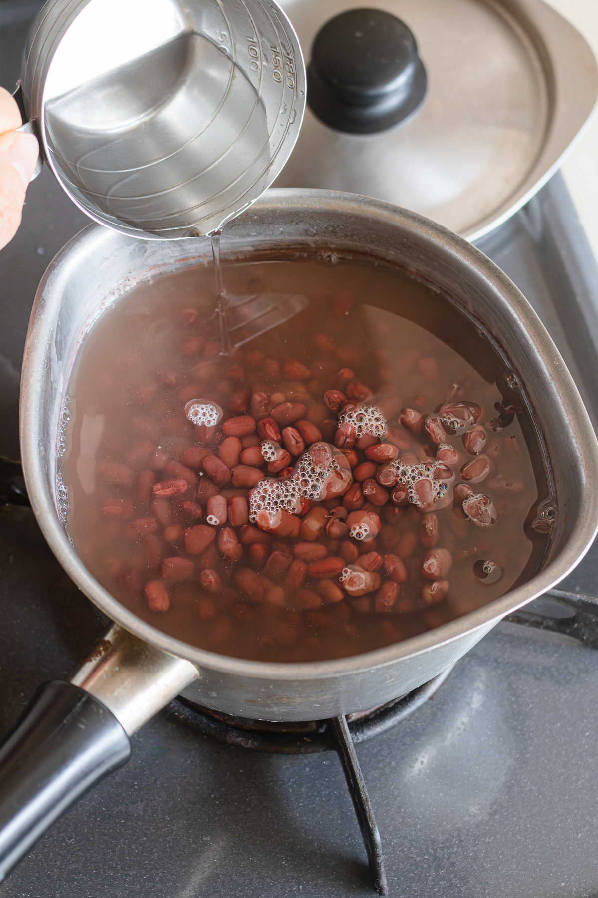 Adding water to adzuki beans returned to the pot