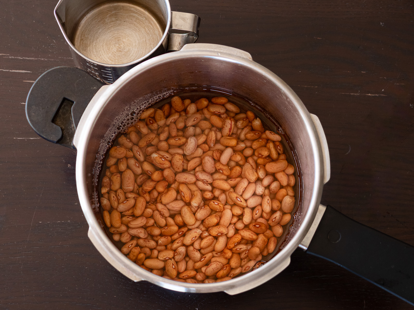  圧力鍋にうずら豆と水を入れている様子
