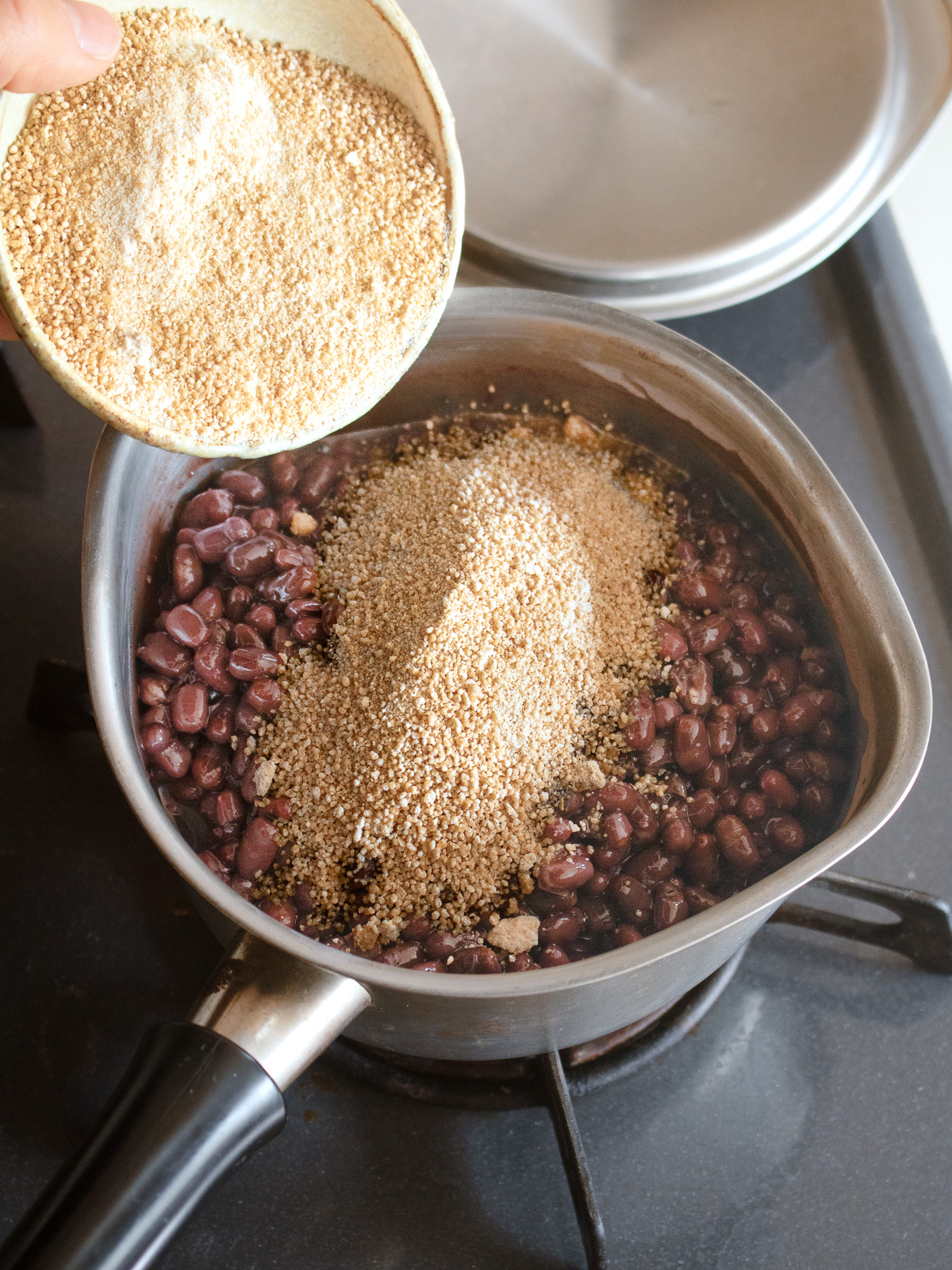 Cooked adzuki beans and sugar combined in a saucepan
