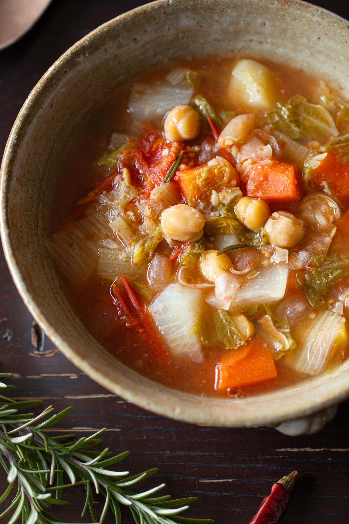 器に盛り付けたひよこ豆のイタリア風トマトスープ。ローズマリーを添えて
