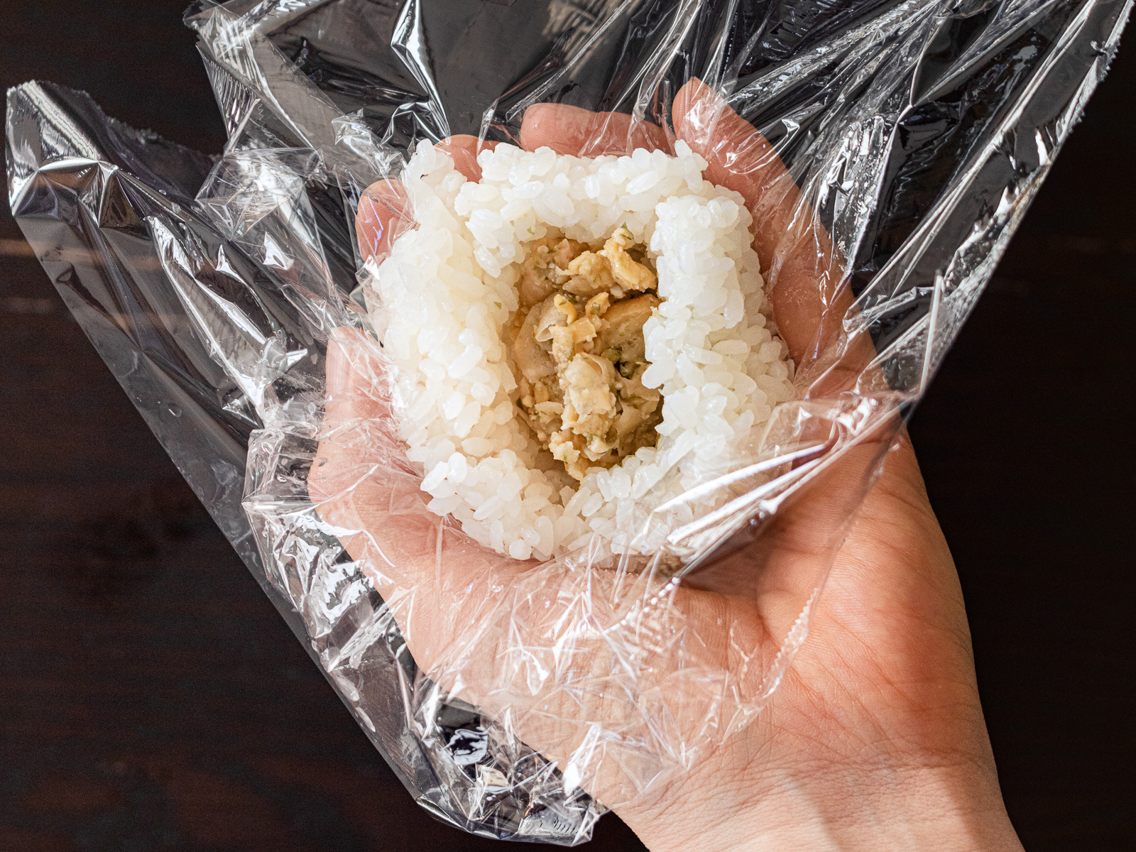 ラップごとおにぎりを手に取る｜ヴィーガン薄焼き卵おにぎりの作り方③