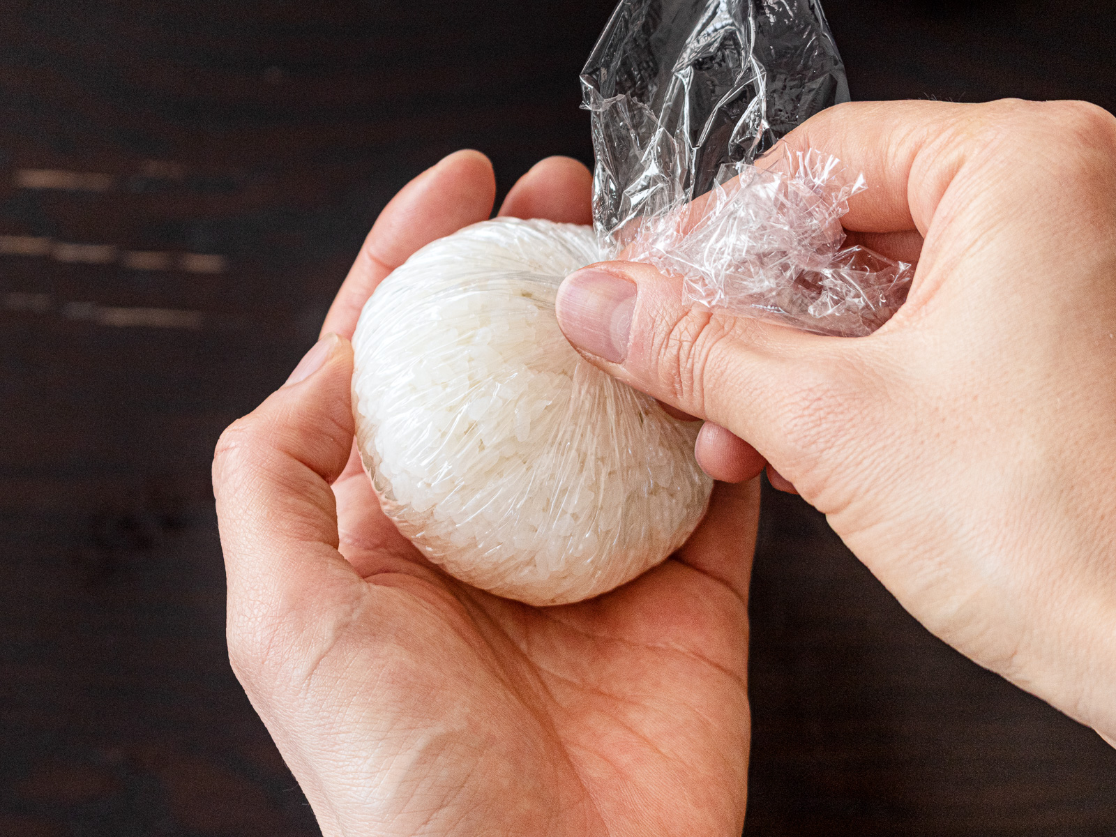 ラップ越しにごはんを中央へ寄せて握る｜ヴィーガンツナマヨおにぎりの作り方④