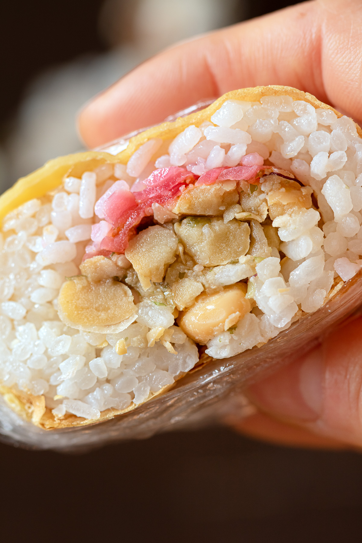 ピンク色の玉ねぎの甘酢漬けを加えたヴィーガン薄焼き卵のツナマヨおにぎりの断面