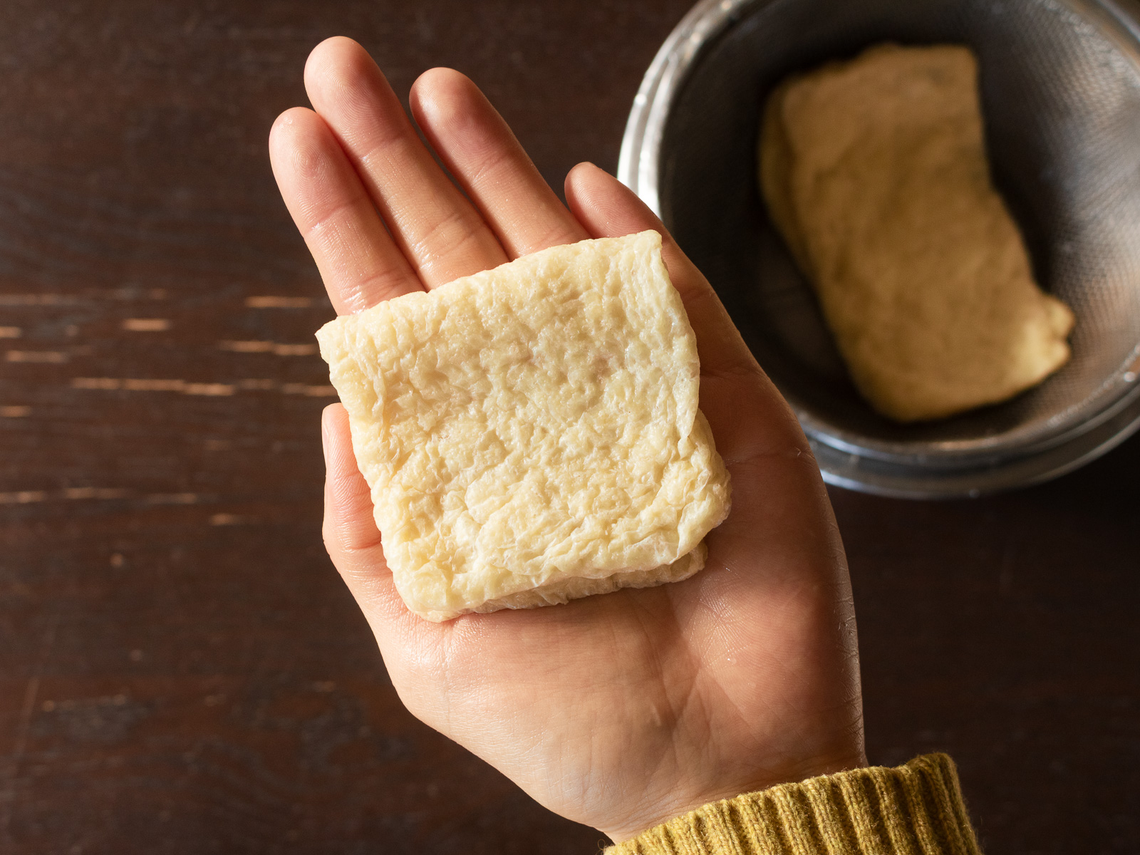 茹でた油揚げの水気を切る