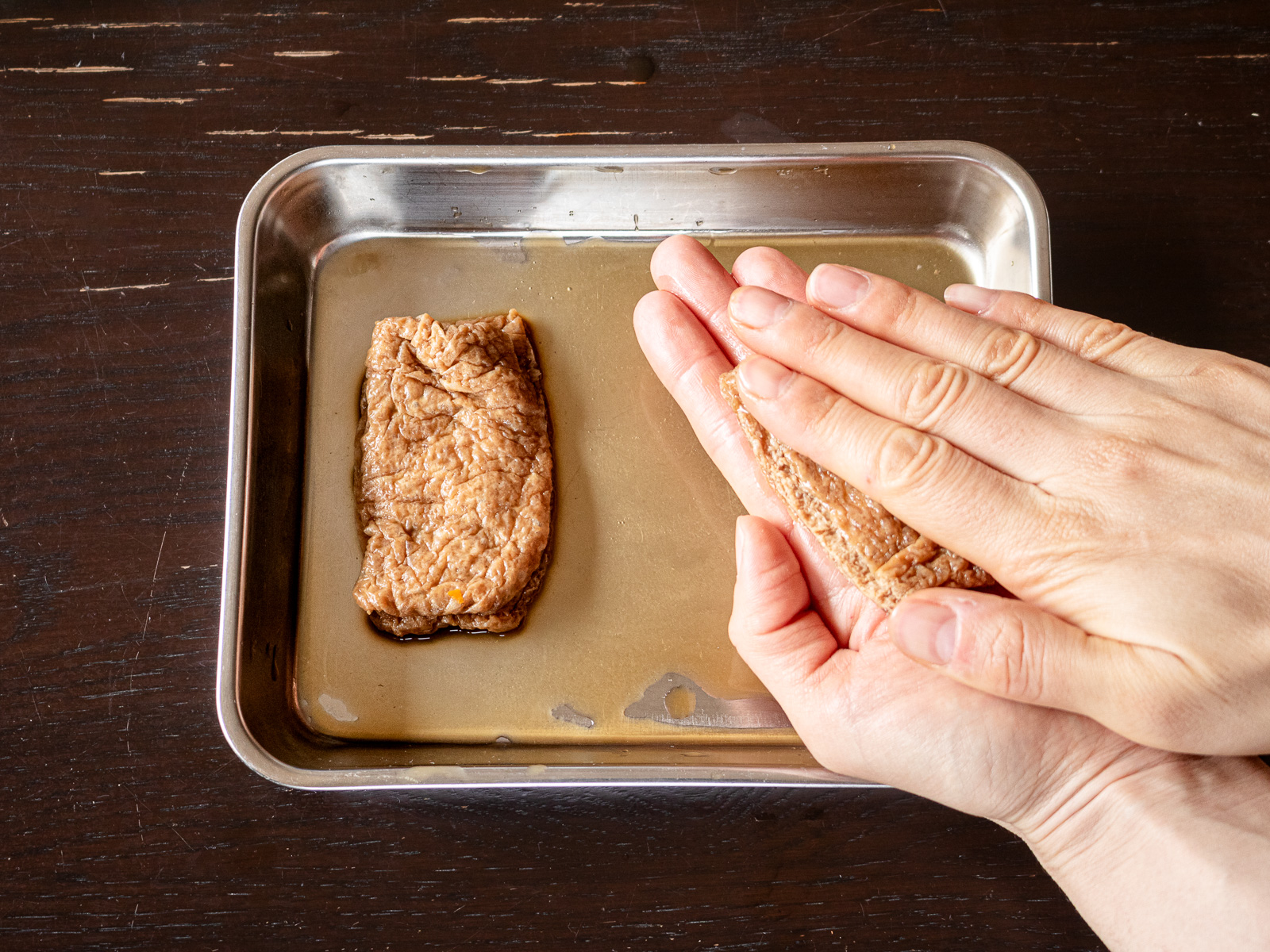お揚げの汁気を手のひらで軽く絞る