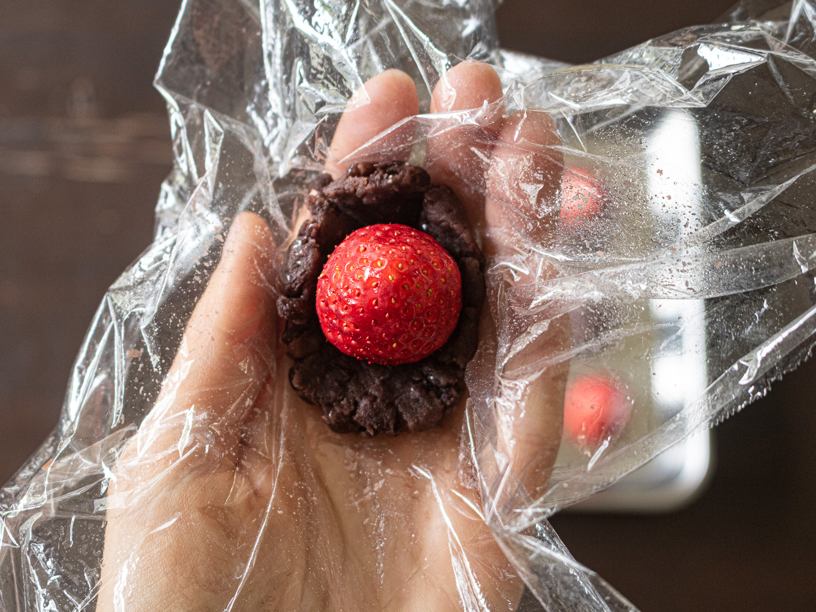 いちご大福のあんこ玉の作り方③いちごをラップに広げたあんこの上に置く