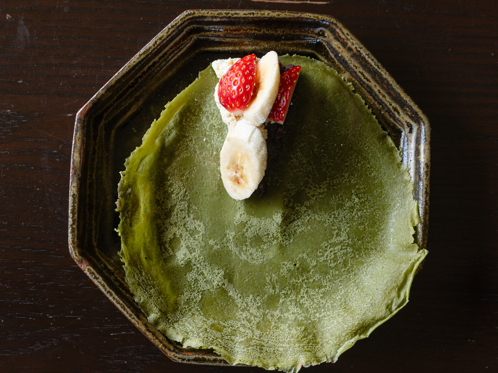 クレープ生地に豆腐クリームとあんこ、スライスしたいちごとバナナを三角形にのせる