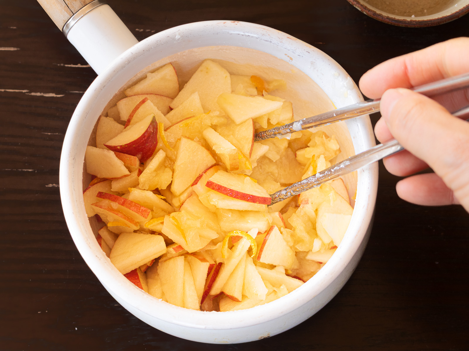 ホウロウ鍋に材料と砂糖を入れて混ぜている様子