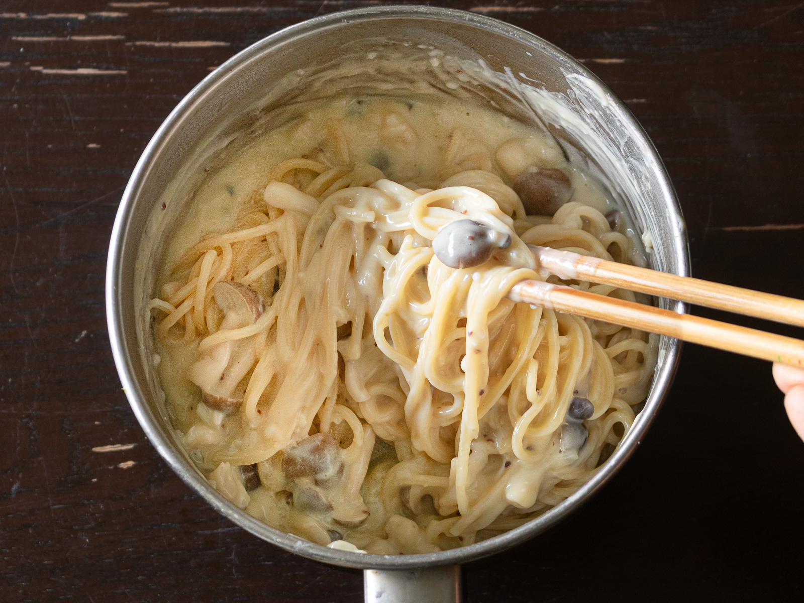 とろっとクリーミーなヴィーガンカルボナーラソースとパスタを絡めた様子