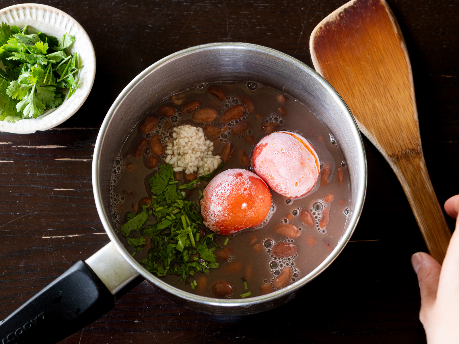 鍋にうずら豆、トマト、塩麹、パクチーの茎を入れたところ