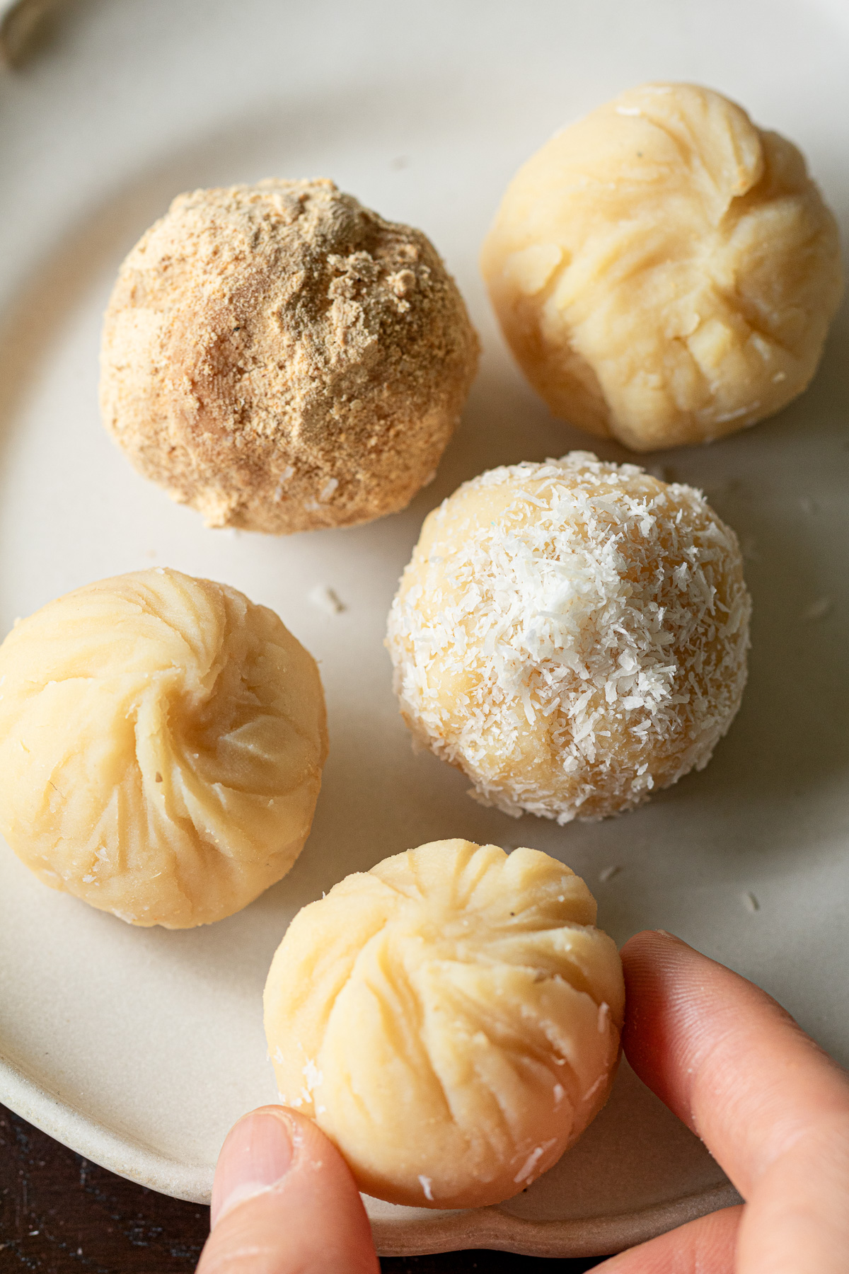 皿に並べた緑豆茶巾。きな粉とココナッツファインをまぶしたヴィーガン和菓子。