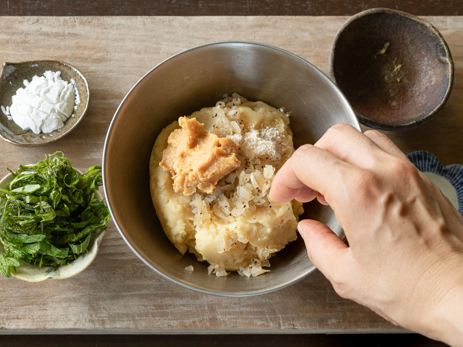 ムング豆マッシュと炒めた玉ねぎ、味噌を混ぜ合わせる様子